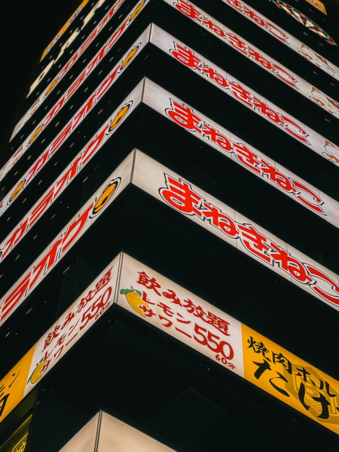 Vibrant neon signs on a night-time urban building create a lively city scene.